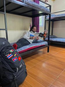 a man laying on a bunk bed with a laptop at Cat Ba Countryside Homestay in Cat Ba