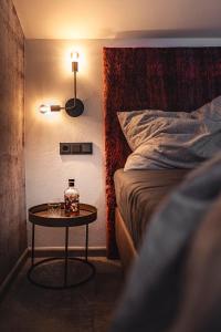 Una habitación con una cama y una mesa con una botella. en PHILSON Apartments en Saalbach Hinterglemm