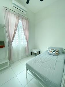 een witte slaapkamer met een bed en een raam bij Cosy House For Family Or Group In Bukit Beruang Melaka in Kampong Pengkalan Batu