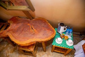 einen Tisch mit einem großen Holztisch mit Teezubehör in der Unterkunft Boma Simba Safari Lodge in Voi