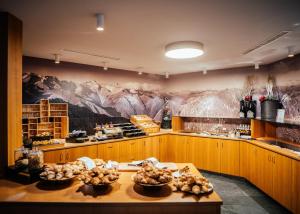 a large kitchen with mountains painted on the wall at Lodenwirt Residence in Vandoies