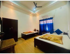 Habitación con 2 camas y mesa. en Hotel Royal City, Chakchaka, WB, en Kuch Bihār