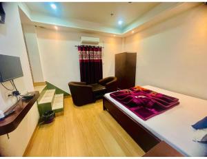 1 dormitorio con 1 cama y 1 silla en una habitación en Hotel Royal City, Chakchaka, WB, en Kuch Bihār