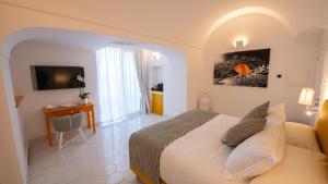 a bedroom with a bed and a desk in a room at Villa Francesco Luxury Suites in Positano