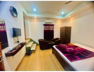 1 dormitorio con 1 cama y 1 silla en una habitación en Hotel Royal City, Chakchaka, WB en Kuch Bihār