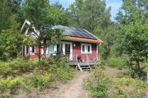 een rood huis met zonnepanelen erop bij Gärdsholmens Skärgårdshemman "Eken" in Edsbruk