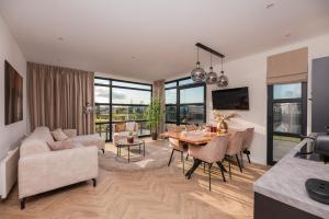 a living room with a table and a dining room at MarinaPark Residentie Nieuw Loosdrecht in Loosdrecht