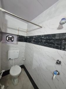 a bathroom with a white toilet and a black and white marble wall at Krishna Homestay in Faizābād