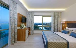um quarto de hotel com uma cama e uma grande janela em İNCEKUM WEST OTEL em Alanya