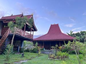 two buildings with red roofs in a garden at JavaLO Villa Lombok in Sengkol