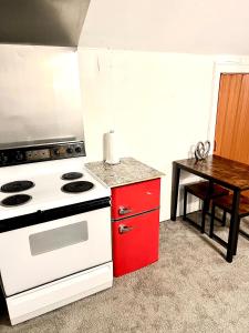 uma cozinha com um fogão branco e um armário vermelho em Two Bedroom Villa Studio with fireplace & Living room em Detroit