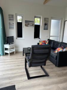 a living room with a couch and a chair at Lauwershuisje sauna Harbor Lauwersmeer in Anjum