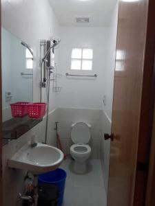 a white bathroom with a toilet and a sink at Roseville Home Stay and Moroccan Spa and Wellness in Baranghauon