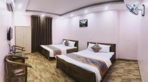 a hotel room with two beds and a television at Minh Thủy Hotel - 32 Nguyễn Chí Thanh, Điện Biên - by Bay Luxury in Diện Biên Phủ