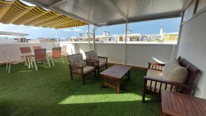 einen Balkon mit Stühlen und Tischen auf dem Dach in der Unterkunft Ático dúplex con vistas in Canet d'en Berenguer