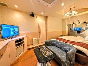 Habitación pequeña con cama y TV. en ホテル　ネグレスコ, en Amagasaki