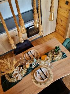une table en bois avec des assiettes et des bols sur le dessus dans l'établissement HelenaHouse22, à Ledinci
