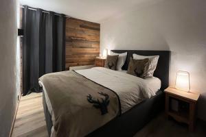 1 dormitorio con 1 cama con pared de madera en Les Cerfs - Appartement & Studio - ANZERE, en Anzère