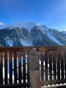 a stone statue sitting on a balcony with a snow covered mountain at Chalet Wiesen in Davos