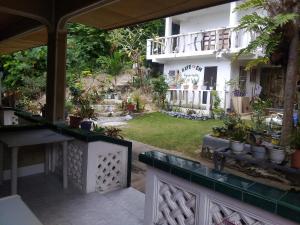 - une vue sur le jardin depuis la terrasse couverte d'une maison dans l'établissement Kaye En Em Apartelle, à Puerto Galera