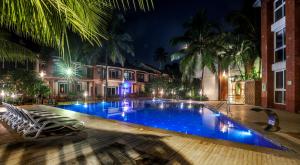 una piscina notturna con sedie intorno di Heritage Exotica Villa - 4BHK, Baga a Baga