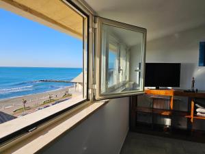 um quarto com uma janela com vista para a praia em Attico Granelli di Sabbia em Lido di Ostia