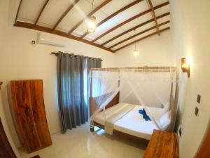 un dormitorio con una cama con mosquitera en Thushen Villa, en Matara