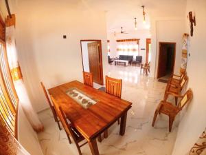Un comedor con mesa y sillas de madera. en Thushen Villa, en Matara