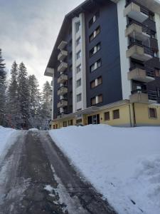 eine schneebedeckte Straße vor einem Gebäude in der Unterkunft Relax aux Paccots : été comme hiver in Les Paccots