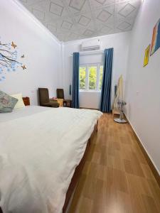 a bedroom with a large bed with blue curtains at Cat Ba Countryside Homestay in Cat Ba