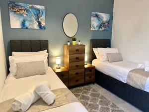 a bedroom with two beds and a mirror on the wall at Hyde Brewery House - 2 bedroom house with parking in Winchester