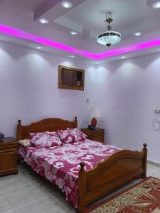 um quarto com uma cama grande e iluminação rosa em شقه عالبحر بجوار هيلتون عاءلات فقط em Alexandria
