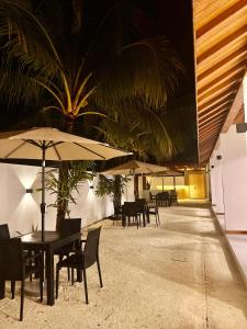 a restaurant with tables and chairs with umbrellas at Vilu Residence in Maamigili