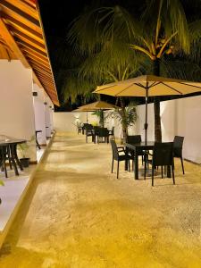 Vilu Residence في ماميغيلي: صف من الطاولات والكراسي مع المظلات