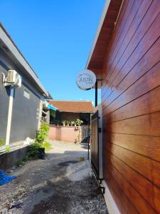 a wooden garage door with a sign on it at Justin Guest House in Jimbaran