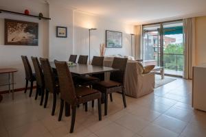 a dining room with a table and chairs at AT177 Pins, dúplex en 1ra línea, con piscina, airco in Torredembarra