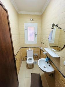 a small bathroom with a toilet and a sink at Luxury Inn 3BR Amazing Garden view in Madinaty B1 in Madinaty