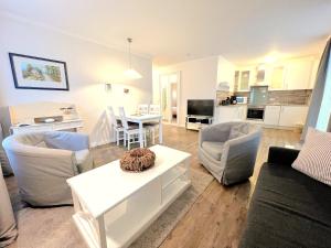 Dünenpark 053 في بينز: غرفة معيشة مع أريكة وكراسي وطاولة