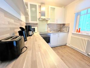 Dünenpark 053 في بينز: مطبخ بدولاب بيضاء وأرضية خشبية