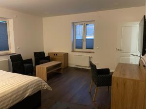 a bedroom with a bed and a desk and chairs at Ferienwohnung Zossen Gästehaus in Zossen