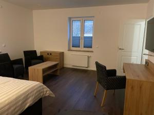 Zimmer mit einem Bett, einem Schreibtisch und Stühlen in der Unterkunft Ferienwohnung Zossen Gästehaus in Zossen