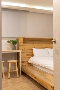um quarto com uma cama de madeira, uma mesa e um banco em Woody Two Bedroom In Hongdae em Seul