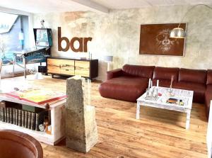 a living room with a leather couch and a table at City-Loft with rooftop terrace - 19 persons in Hannover