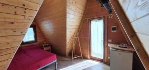 Habitación pequeña con banco rojo en una cabaña de madera en Oasi del Sangro, en Castel di Sangro