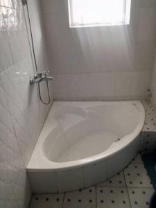 a white bath tub in a bathroom with a window at KIVU SUNSET GUEST HOUSE in Gitesi