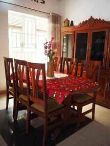 een eettafel en stoelen met een rode tafelkleed bij KIVU SUNSET GUEST HOUSE in Gitesi