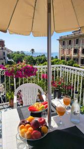 una mesa con una bandeja de fruta en una mesa con una sombrilla en B&B Divina Salerno, en Salerno