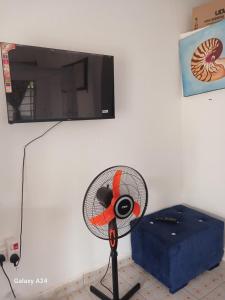 un ventilatore seduto accanto a un muro con TV di Hideout a Ukunda