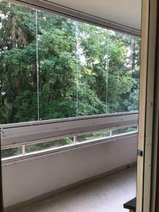 a window in a room with a view of trees at 30m2 studio - 500m from train station to Airport and Helsinki city centre in Vantaa