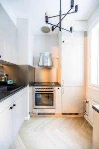 a kitchen with white cabinets and a stove top oven at 30m2 studio - 500m from train station to Airport and Helsinki city centre in Vantaa
